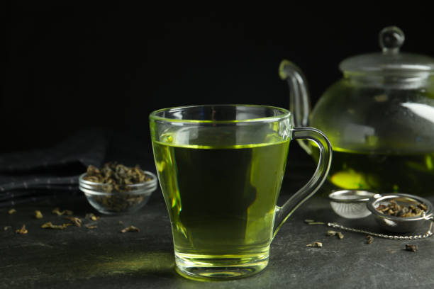 istock Cup of aromatic green tea on grey table 1346557834