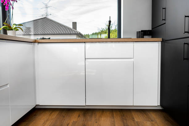 istock A modern kitchen with built in cabinets against the wall with white fronts, vinyl panels on the floor. 1346558316