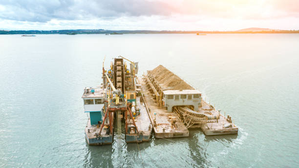 ein flussschiff extrahiert sand vom grund des flusses. reinigung des flusses von schlamm - industrial ship earth mover barge yellow stock-fotos und bilder