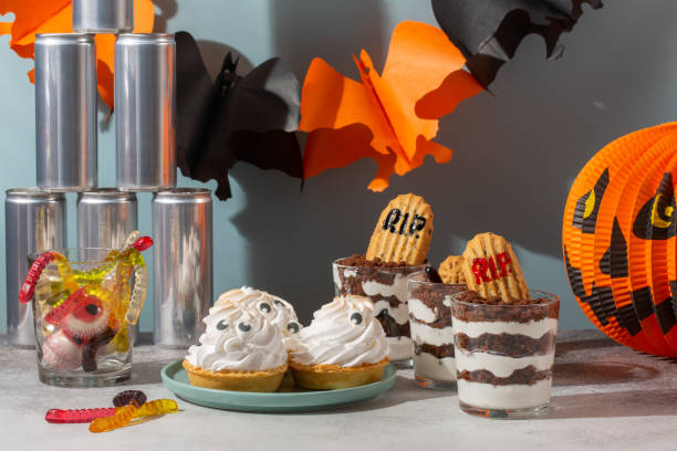 istock Sweets for Halloween party. Halloween candy buffet. Graveyard trifle  dessert cups,  ghost meringue tarts and scary gummies in Halloween decorations. 1346561216