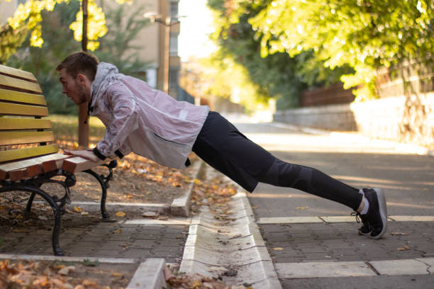 istock Young man doing push-ups on the park bench stock photo 1346562298