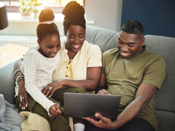 istock Shot of a young couple sitting on the sofa with their daughter and bonding while using a laptop 1346563198