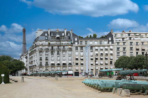 Paris, France - July 3, 2009:  Historic cannons outdoors at military museum, in front of elegant apartment buildings