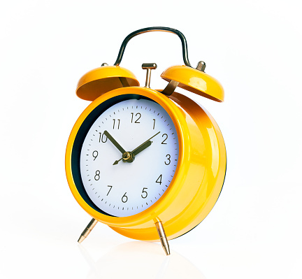 Retro style alarm clock on yellow background.