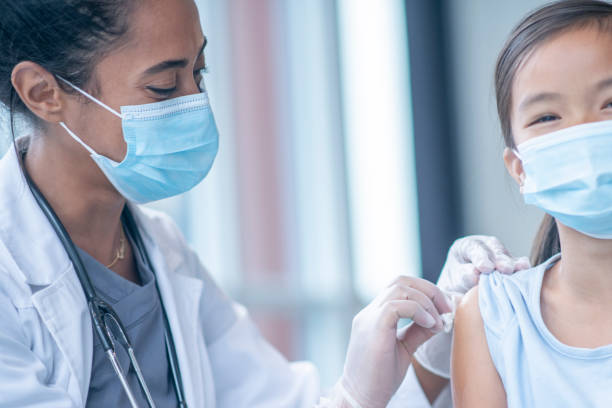 istock Doctor Preparing a Young Girls Arm for Vaccination 1346566676