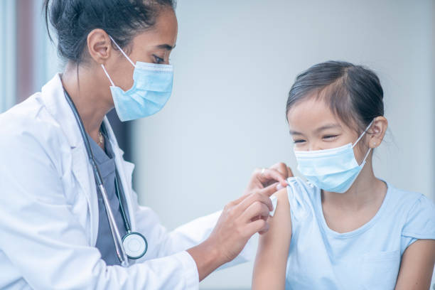 Doctor Preparing a Young Girls Arm for Vaccination
