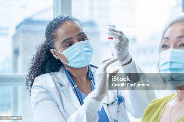 Doctor Filling A Syringe From A Vial Stock Photo - Download Image Now - Vaccination, Vial, Patient