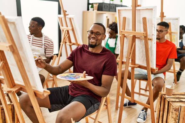 grupo de jovens artistas afro-americanos sorrindo desenho feliz no estúdio de arte. - artist young adult artists canvas adult - fotografias e filmes do acervo