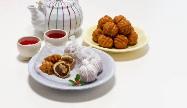 Photo of Small walnut-flavored cakes in the size and shape of a walnut on the plate. Dessert table setting with copy space isolate on white background.