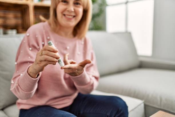 istock Middle age diabetic woman measuiring glucose using glucometer at home. 1346567783