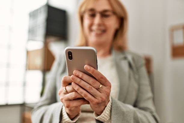 istock Middle age businesswoman smiling happy using smartphone at the office. 1346567870