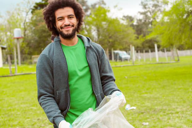 un bénévole de sexe masculin ramassant des déchets dans un sac en plastique - bag garbage bag plastic black photos et images de collection