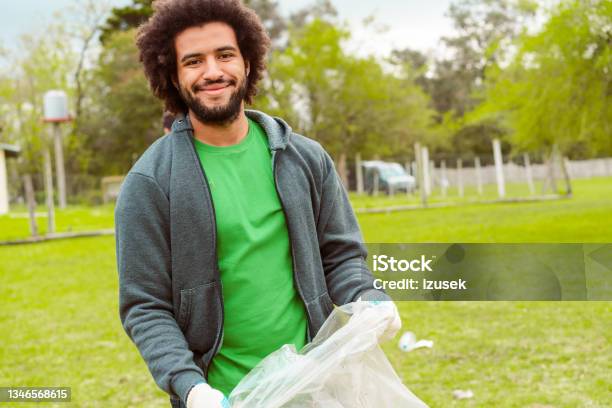 Male Volunteer Collecting Litter In Plastic Bag Stock Photo - Download Image Now - Volunteer, Men, Recycling