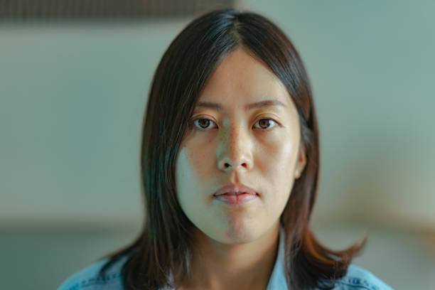 istock Young woman sitting on bed and looking at camera 1346568860