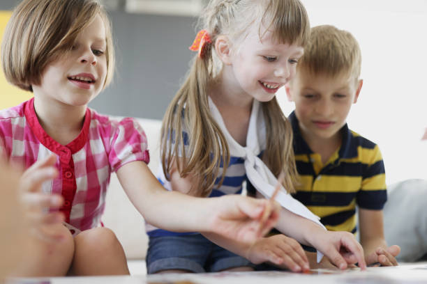 istock Cheerful smiling children playing board games at table 1346569074
