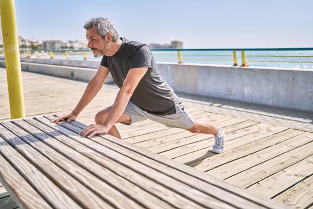 istock Middle age hispanic man wearing sportswear stretching at seaside 1346569424