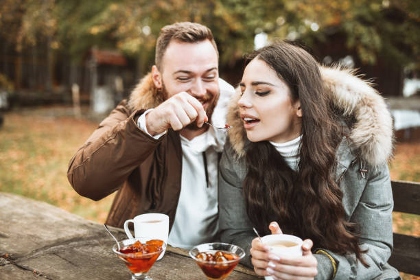 istock Male Feeding Slatko To Girlfriend While Enjoying Tea During Forest Vacation 1346570961