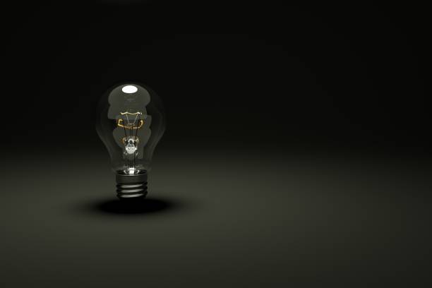 3D model of an unlit transparent light bulb on a black isolated background. Dark background with a glass bulb on it. 3D graphics, black background