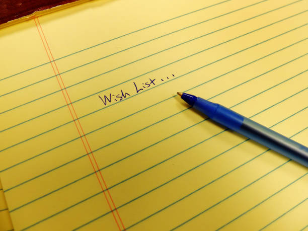 istock Wish list written in blue ink on notebook with blue pen 1346573265