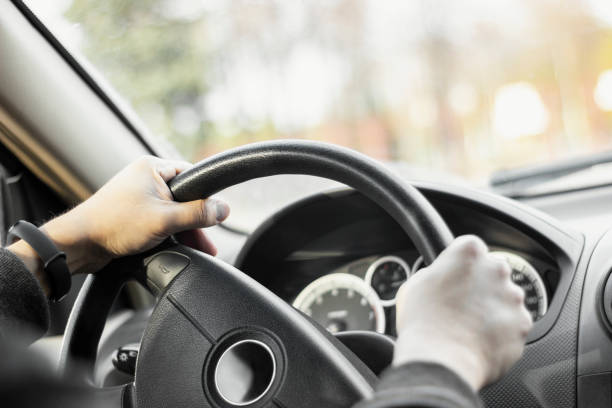 istock Man holding steering wheel and driving his car 1346573508