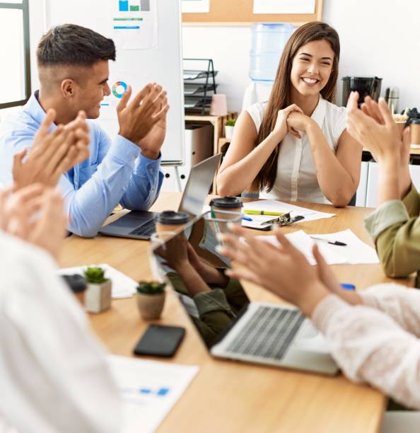 istock Group of business workers smiling and clapping to partner at the office. 1346573842