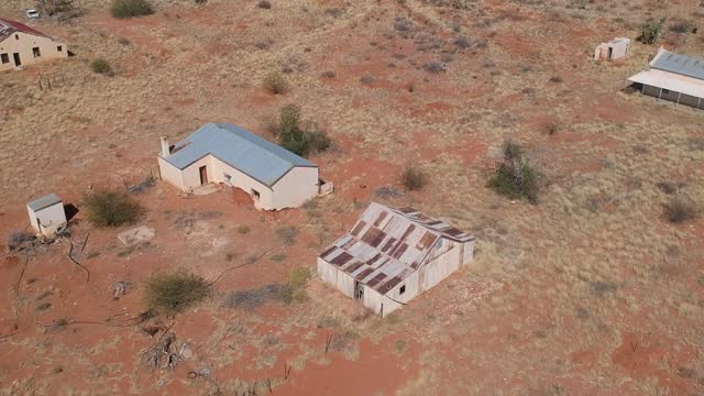 A high point of view of abandoned buildings and gravel road of the ghost town of Putsonderwater camera moving lower Aerial video