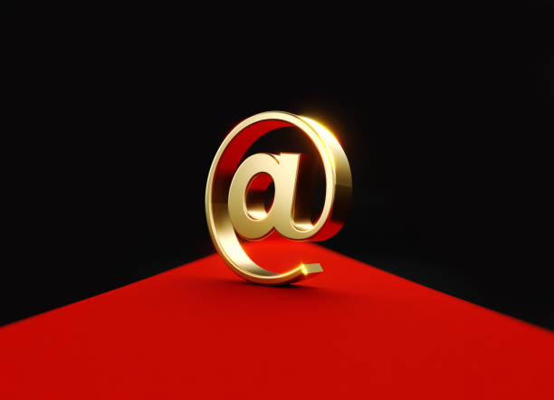 Gold colored at symbol sitting on red carpet. Horizontal composition with copy space. Front view.