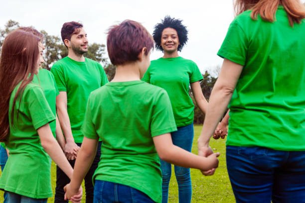 istock Volunteers holding hands during cleanup in park 1346574598