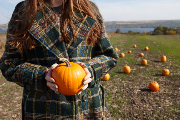 istock Woman walking in Halloween pumpkin patch in sunny day 1346574670