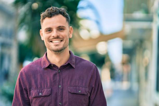 istock Young hispanic man smiling happy standing at the city. 1346574698