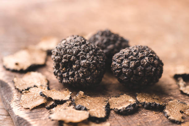 black truffles on the old wooden table, rustic style, selective focus - truffle tuber melanosporum mushroom 個照片及圖片檔