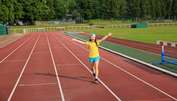 Children participating in a relay race on a stadium track, showcasing teamwork, determination, and active lifestyles while enjoying a day of sports and fun.
