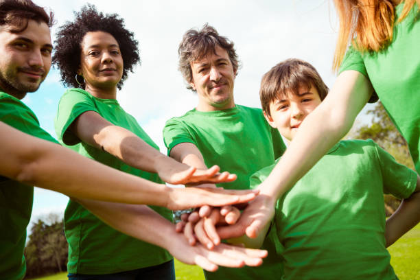 istock Volunteers stacking hands during cleanup in park 1346576490