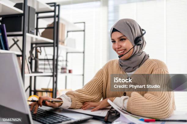 Black Islamic Lady In Hijab And Headset Having Video Call On Laptop Stock Photo - Download Image Now
