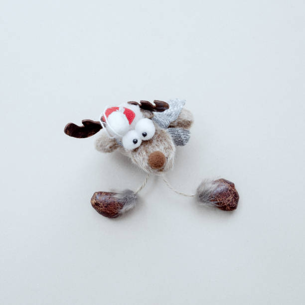 istock A funny soft toy deer with bulging eyes sits on a white background. Christmas decor. Top view 1346577093