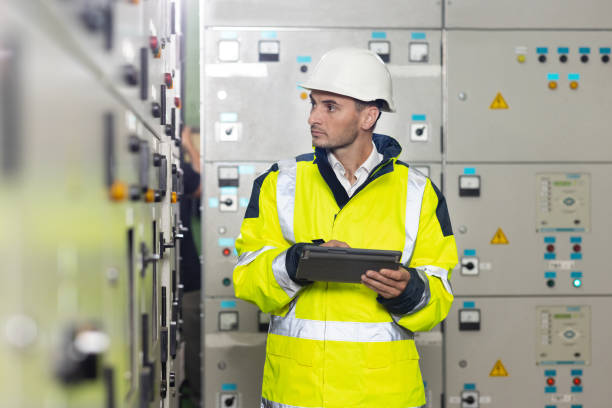 istock Technician inspect to control panel screen system for generate electricity of factory in manufacture industrial. Man electrical engineer hold tablet monitoring electrical system in control room 1346578631