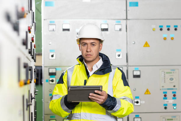 istock Asian man electrical engineer hold tablet monitoring electrical system in control room. Technician inspect to control panel screen system for generate electricity of factory in manufacture industrial 1346578705