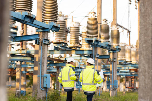 istock Engineers men in warm clothes use digital tablet computer discuss work walking against power electric substation 1346580239
