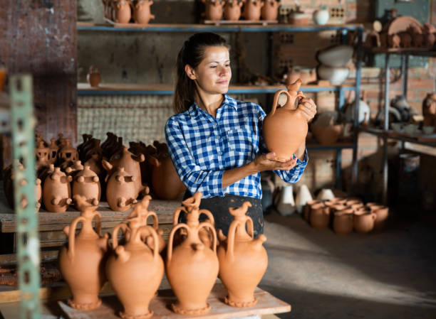 istock Female artisan in apron  having ceramics in stock 1346580603