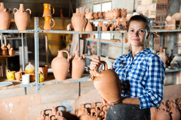 istock Woman chooses pots clay pots in store warehouse 1346580604
