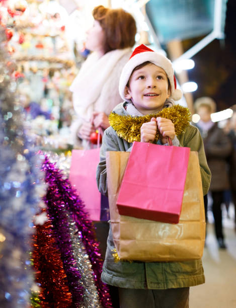 istock Boy with bags on Christmas market 1346582184