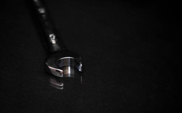 istock Wrench on shiny black surface. Universal professional tool for car repair. 1346582352