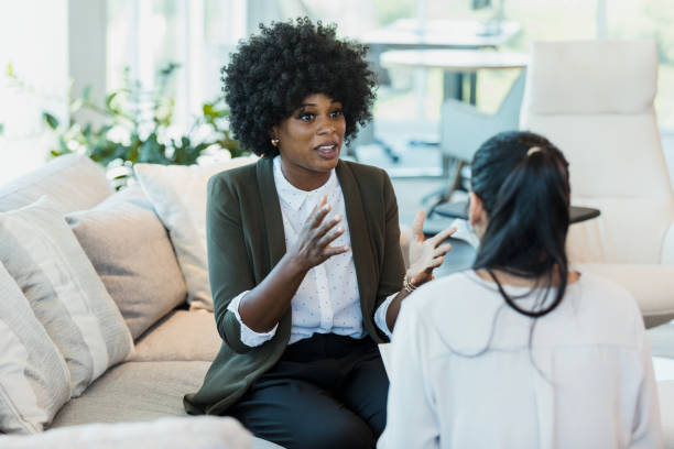 istock Female manager gestures while talking with unrecognizable female employee 1346582407