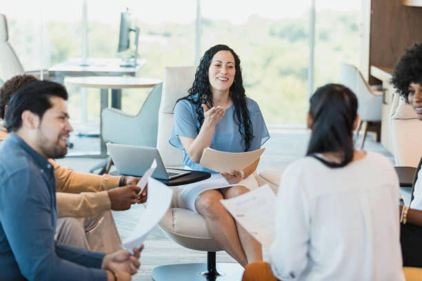 istock Female manager gestures to unrecognizable female presenter 1346582425