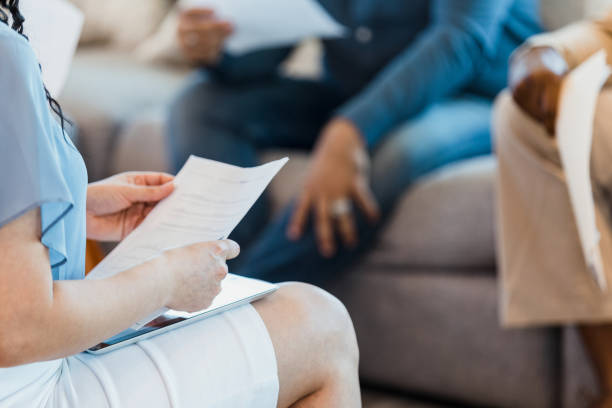 istock Unrecognizable woman with tablet in lap and paper in hands 1346582443