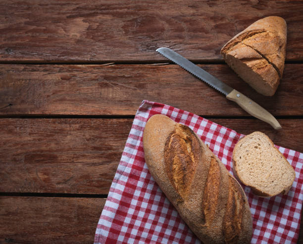 istock Composition of freshly baked bread on old wooden background 1346583385