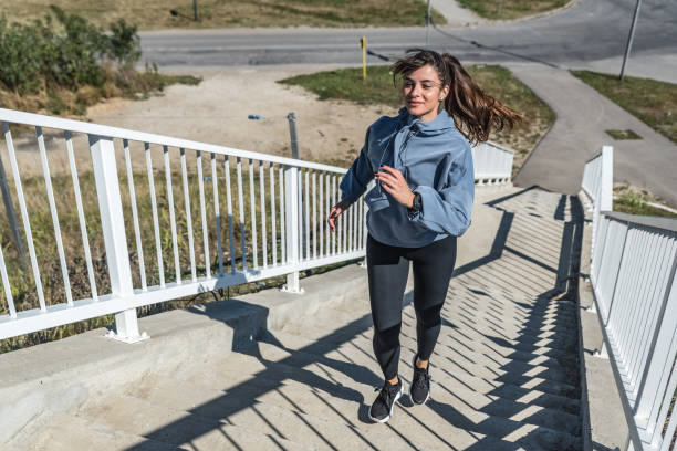 若いアクティブフィットネススポーティな女性は、健康的な生活のためのハードコアカーディオワークアウトトレーニングを行うスポーツワードローブで階段を駆け上がり、マラソンランナ� - marathon sport sports training city street ストックフォトと画像