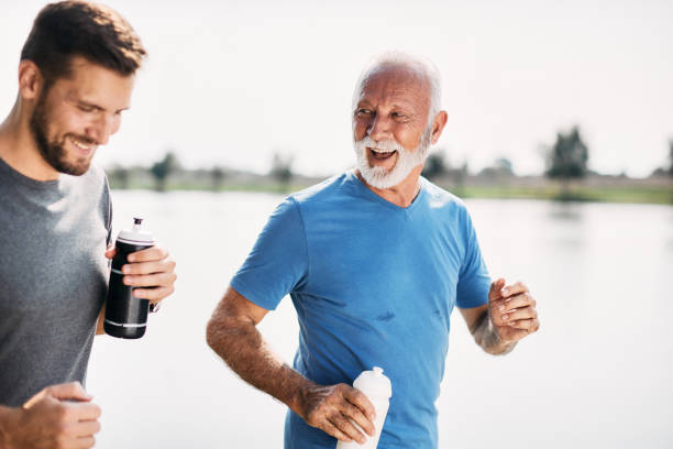 istock Happy senior athlete having fun while running with his son in nature. 1346583450