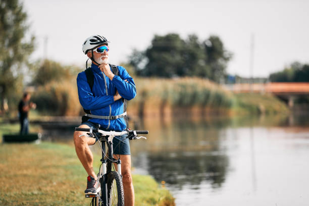 istock Senior cyclist enjoying the view while taking a break by the lake. 1346583532