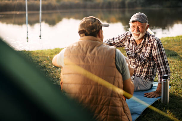 istock Happy senior man talking to his son while camping in nature at sunset. 1346583602
